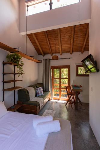 a bedroom with a bed and a living room with a couch at Casa Teiú in São Sebastião