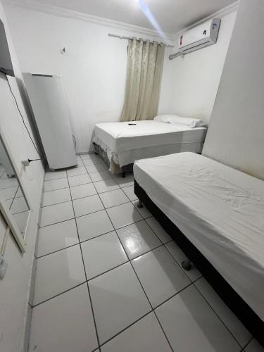 a small room with two beds and a window at Pousada Iracema Centro in Fortaleza