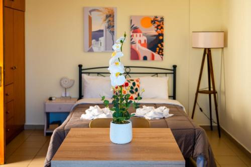 a bedroom with a bed and a table with a flower at Kanali seaside apartment Poros 2 in Poros