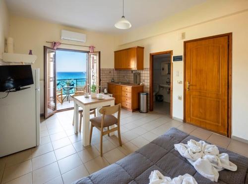 a kitchen with a table and a kitchen with a view of the ocean at Kanali seaside apartment Poros 2 in Poros