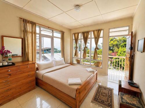 a bedroom with a bed and a large window at Shikher Guest House in Kalimpong