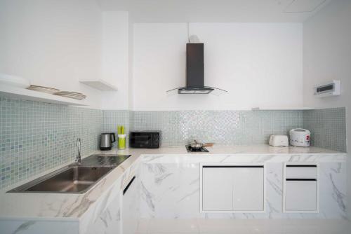 a white kitchen with a sink and a counter at Prima Villas Chalong Phuket in Chalong