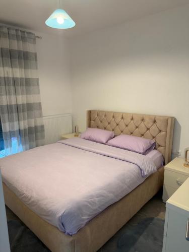 a bedroom with a large bed with purple pillows at Dragoti in Leptokarya