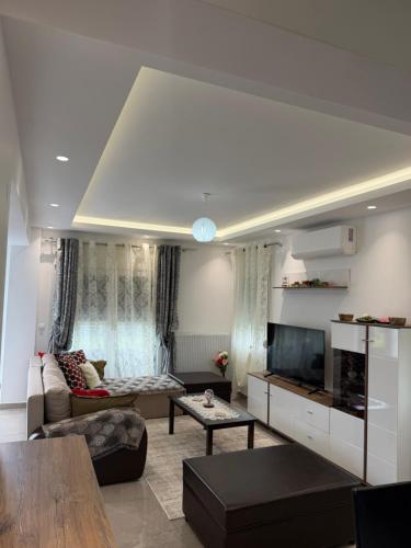a living room with a couch and a tv at Dragoti in Leptokarya