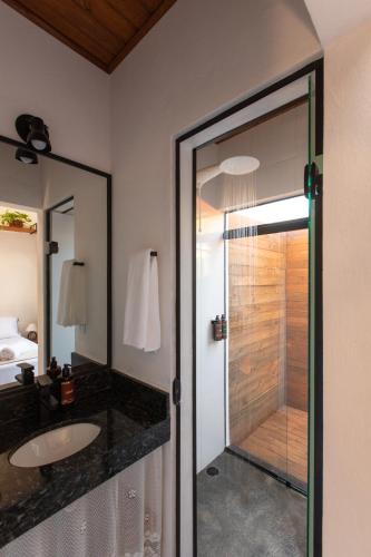 a bathroom with a sink and a glass shower at Casa Teiú in São Sebastião