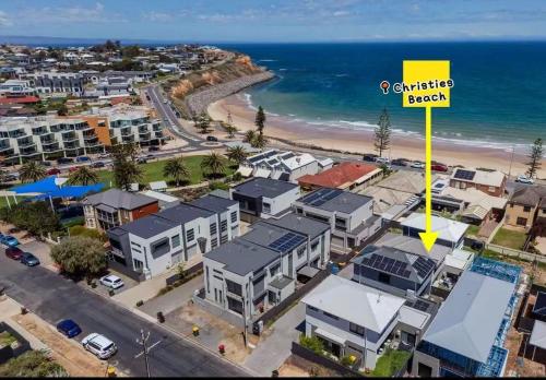 an aerial view of a coastal neighbourhood with a yellow arrow at Steps to the Beach Cafes moderm stylish 3BR in Christies Beach