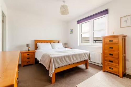 a bedroom with a bed and a dresser and a window at Irvine Harbor Apartments in Irvine