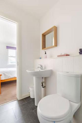 a white bathroom with a toilet and a sink at Irvine Harbor Apartments in Irvine
