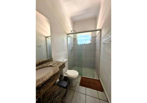 a bathroom with a toilet and a sink and a shower at GrandMaré Hotel in Peruíbe