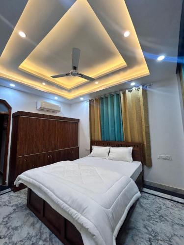 a bedroom with a large bed with a ceiling at The great Garuda hotel in Rishīkesh