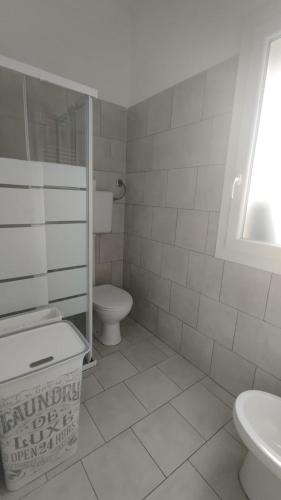 a white bathroom with a toilet and a sink at Leo's Villa in Milano Marittima