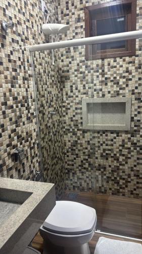 a bathroom with a toilet and a shower at Pousada e Hotel Mirasol in Mato Verde