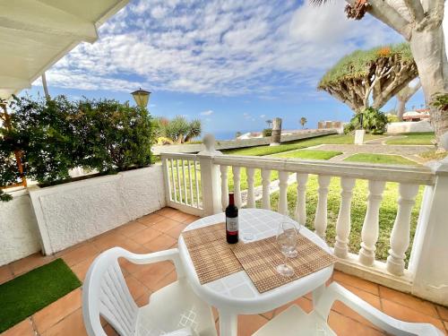 a table and chairs on a balcony with a bottle of wine at Blue Oasis in Tacoronte