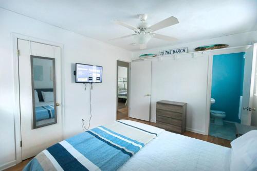 a bedroom with a bed and a ceiling fan at Central OBX Getaway with Pool and Sound Access in Nags Head
