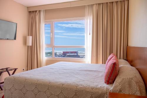 ein Schlafzimmer mit einem Bett und einem großen Fenster in der Unterkunft Sul Mare Hotel in Valeria del Mar