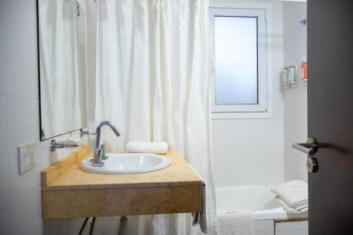 ein weißes Badezimmer mit Waschbecken und Dusche in der Unterkunft Sul Mare Hotel in Valeria del Mar