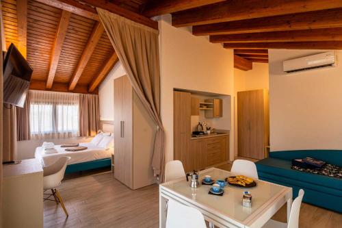 a room with a bed and a table and chairs at Club del Sole Desenzano Boutique Resort in Desenzano del Garda