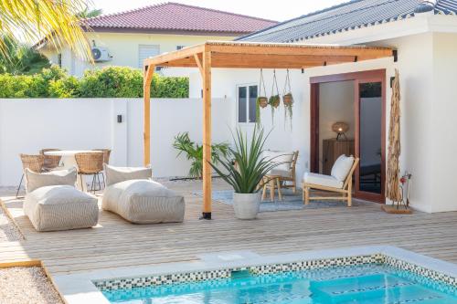 a patio with a pool and a pergola at Villa CuraNova in Jan Thiel