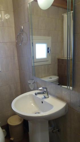 a bathroom with a sink and a mirror and a toilet at Studio Katerina in Kimolos