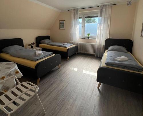a room with three beds and a window at Pension Highway - Löhne Löhner Straße 111 in Löhne