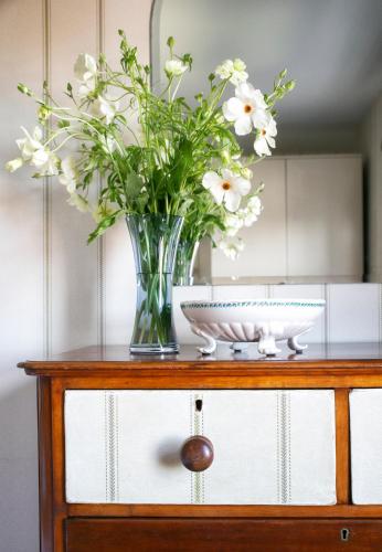 a vase of flowers sitting on top of a dresser at The Green House deluxe 2 bedroom upper floor apartments in Harrogate