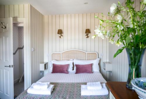 a bedroom with a bed with pink and white pillows at The Green House deluxe 2 bedroom upper floor apartments in Harrogate
