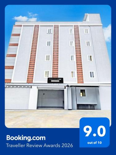 a large white building with a garage at Super Townhouse Oak Kompally in Hyderabad
