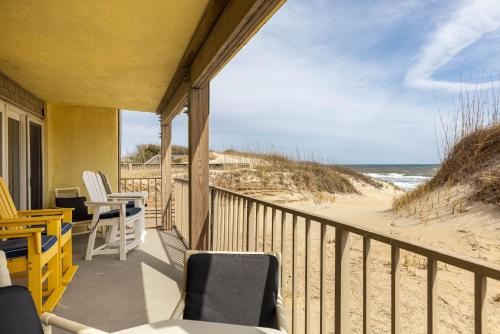 a balcony with chairs and a view of the beach at DL104 - Dune's Watch in Nags Head