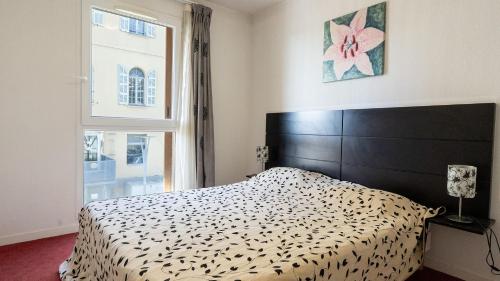 a bedroom with a black and white bed and a window at Virginia N309 2P4 in Grasse