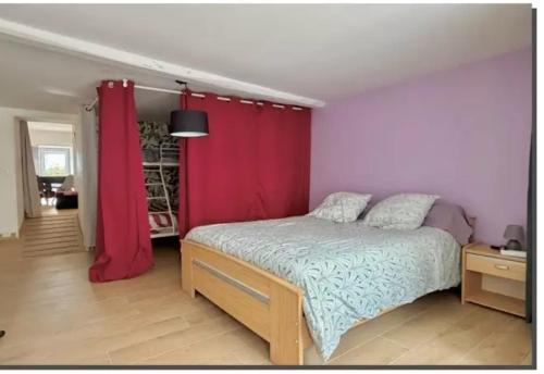 a bedroom with a bed with a red curtain at Le repos beaurepairien in Beaurepaire