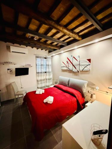 a bedroom with a red bed and a tv at Il Nido della Regina - 250m dal Lago di Bolsena in Marta