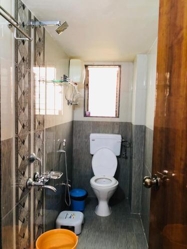 a small bathroom with a toilet and a shower at BEACH STAYs in Revadanda