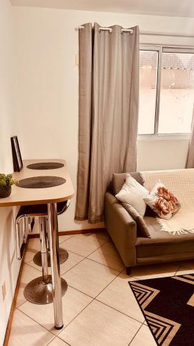 a living room with a couch and a table at Apartamento perto do HCAA - com Garagem in Santa Maria