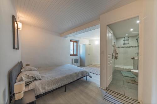 a bedroom with a bed and a bathroom at Le Gerbolle in Reventin-Vaugris