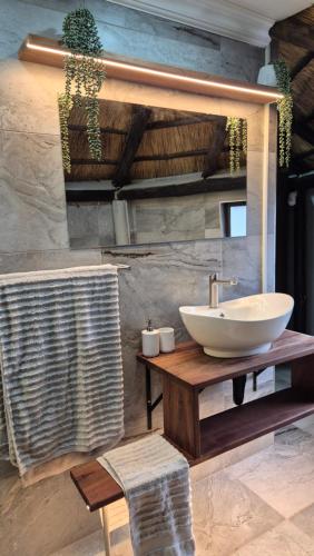 a bathroom with a white sink on a wooden table at Bootleg Inn in Welkom