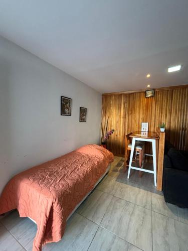 a bedroom with a bed and a table in it at Amanecer Rio Limay in Plottier