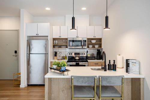 a kitchen with white cabinets and a refrigerator at Modern & Spacious 2BR Apartment with Gym & Parking in New Haven