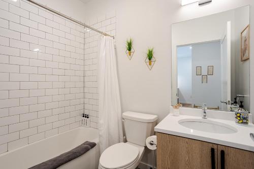 a white bathroom with a toilet and a sink at Modern & Spacious 2BR Apartment with Gym & Parking in New Haven