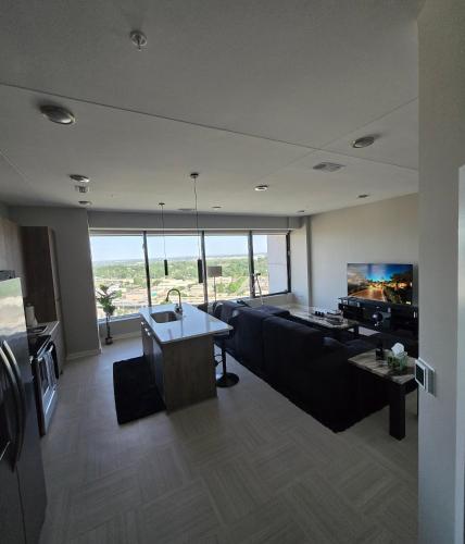 a living room with a couch and a tv at Immaculate Vibes Sunset View Condo in Birmingham