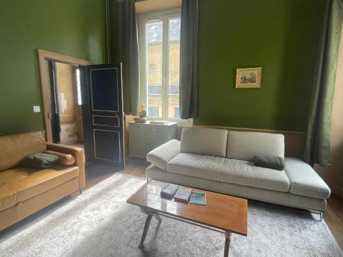 a living room with a couch and a coffee table at Le Louis d'Or in Beaumont-sur-Sarthe