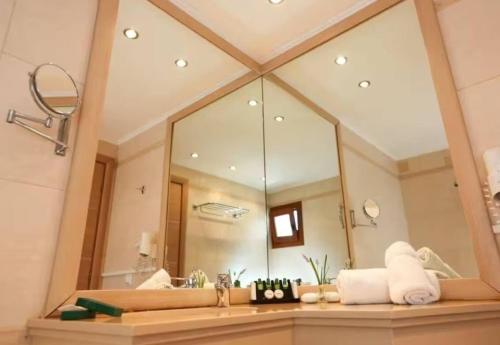 a bathroom with a large mirror and a sink at Cave Luxury Villas Skiathos in Troulos