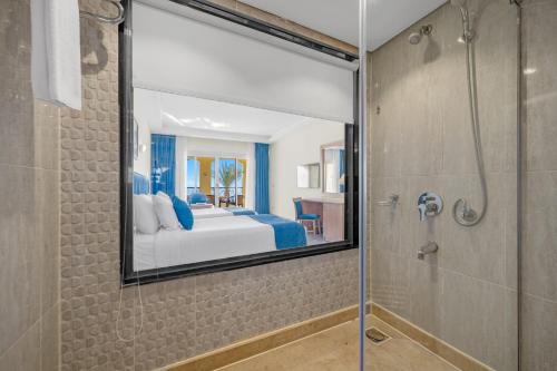 a bedroom with a bed and a shower and a mirror at Grand Oasis Resort in Sharm El Sheikh