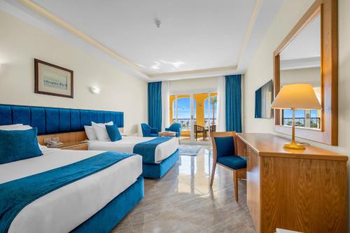 a hotel room with two beds and a desk at Grand Oasis Resort in Sharm El Sheikh