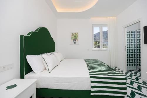 a white bedroom with a green and white bed at Palazzo Sant'Elena in Anacapri