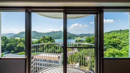 a room with a view of a river and mountains at Resorpia Kumihama in Kyotango