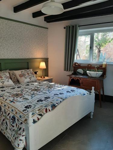 a bedroom with a bed and a sink and a window at Mulberry Tree Cottage Episkopi Paphos in Episkopi Pafou