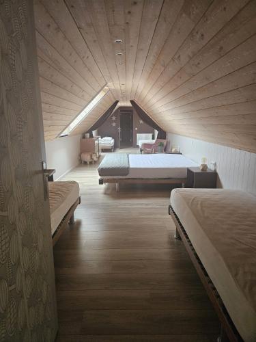 a bedroom with two beds and a large wooden ceiling at B&B Chocla-dort in Koekelare