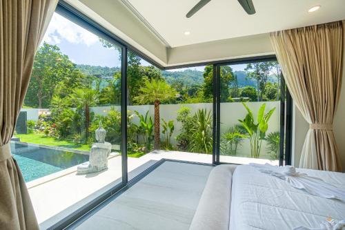 a bedroom with a bed and a large glass window at Villa Babylon Chaweng in Koh Samui