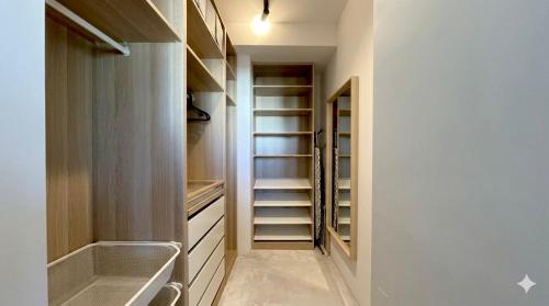 a walk in closet with wooden cabinets and shelves at Apartamant Oaza II in Koszalin