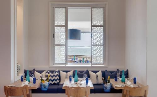 a dining room with a blue couch and a window at Strand Hotel Swakopmund in Swakopmund